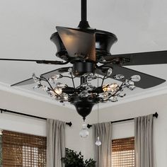 a black ceiling fan with lights hanging from it's blades in a living room