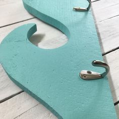 a pair of scissors are sitting on a piece of blue wood that has been cut into the shape of a letter s