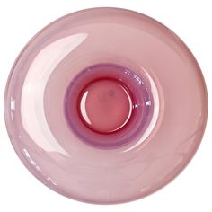 a close up of a pink glass bowl on a white surface with a red liquid in the center