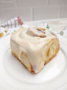 a white plate topped with a pastry covered in icing