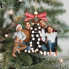 an ornament hanging from a christmas tree with family and dog on it's side