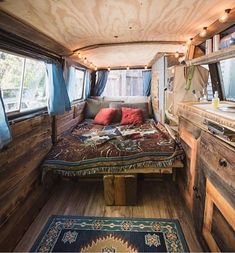 the interior of a camper with wood paneling and blue rugs on the floor