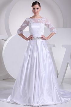 a woman in a white wedding dress standing on a white background with her hands on her hips