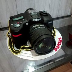 a cake made to look like a camera on top of a plate with the photographer's name written on it