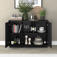 a black cabinet with plates, cups and bottles on it next to a potted plant