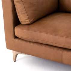 a brown leather couch sitting on top of a white floor