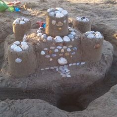 a sand castle made out of shells on the beach