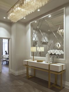 a large mirror sitting on top of a white counter next to a table with flowers