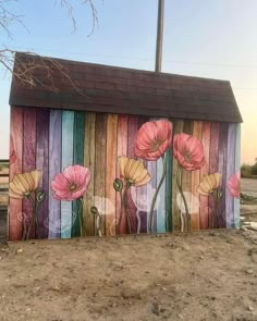 a painted wooden fence with flowers on it