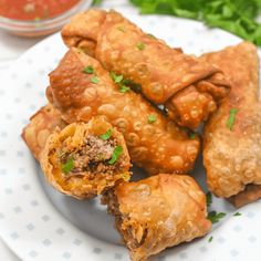 some food is sitting on a plate with dipping sauce in the bowl next to it