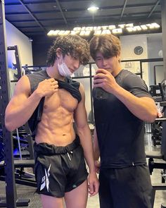 two men standing next to each other in a gym