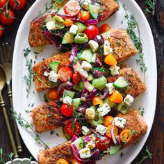 chicken with tomatoes, cucumber, red onion and feta cheese on a white plate