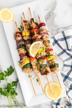 chicken kabobs on skewers with lemon and parsley garnish