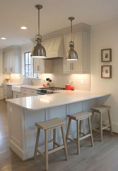 a kitchen with two stools next to an island