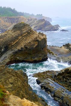 an ocean view with waves crashing on the rocks