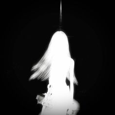 a woman with long hair standing in the dark