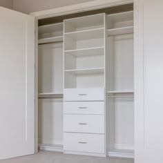 an empty white closet with drawers and shelves