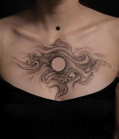 a woman's chest with an artistic tattoo on it