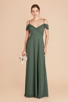 a woman in a green bridesmaid dress standing with her hands on her hip