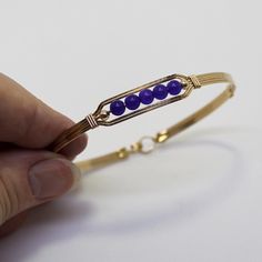 A sweet little bracelet of five strands of 14kt gold filled wire with a center design featuring five 4mm genuine amethyst beads and accented with two smaller beads. Perfect for that February birthday girl! Stackable, too, along with many of my other wirewrapped bracelets! The sturdy built-in hook and eye clasp is easy to get on and off by yourself. Choose the size you need for a comfortable custom fit. Also available in sterling silver. Adjustable Everyday Jewelry Band, Elegant Nickel-free Bracelets For Friendship, Adjustable Nickel Free Gold Bracelet, Adjustable Nickel-free Gold Bracelet, Hand Wrapped Wrap Bracelet Bangle For Friendship, Hand Wrapped Bangle Wrap Bracelet For Friendship, Handmade Wrap Bracelet Bangle For Friendship, Gold Hand Wrapped Friendship Bracelets As Gift, Gold Hand-wrapped Bracelets For Gifts