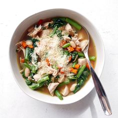 a white bowl filled with chicken and veggies covered in parmesan cheese