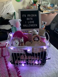 a basket filled with lots of items sitting on top of a white table covered in purple lights