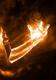 a person holding out their hand with fire in the air behind them on a dark background