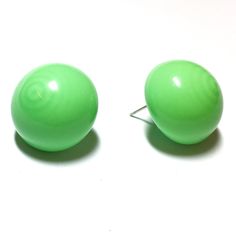 Bright green stud earrings in a retro button stud style with a shiny opaque finish. The line of 'Retro Button Studs' is reminiscent of a retro clip on earring, only these have been made into a modern pierced stud set. Each measures about 22mm or just under 1" in diameter. Most all earrings are made with vintage lucite parts that were made in Rhode Island in the 1960's - early 80's by Best Plastics. We hand-set them with surgical steel earring posts and they have sturdy surgical steel/acrylic bac Green Stud Earrings, Button Studs, Cute Stud Earrings, Clip On Earring, Green Retro, Surgical Steel Earrings, Stud Style, Stud Set, Vintage Lucite