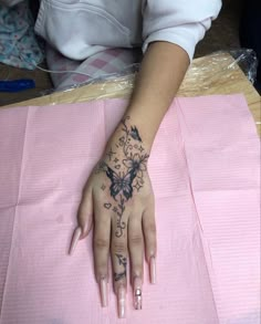 a woman's hand with a butterfly tattoo on it