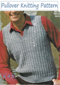 a man wearing a sweater vest and red shirt is standing in front of the water