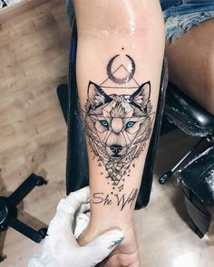 a person with a tattoo on their leg that has an image of a wolf in the middle