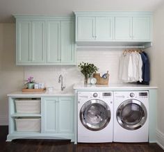 a washer and dryer in a laundry room with cabinets on either side of the washer