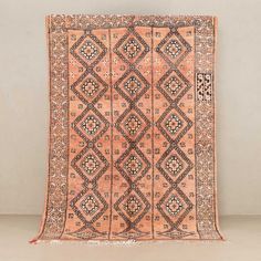 an antique persian rug is displayed against a white wall with black and orange accents on it