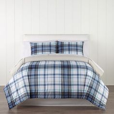 a blue and white plaid comforter set on a bed