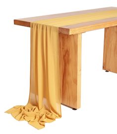 a wooden table with a yellow cloth draped over it