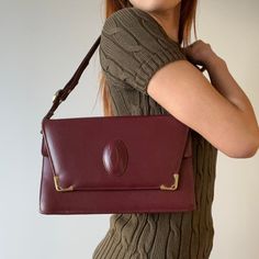 Cartier Burgundy Leather Bag with gold hardware, featuring a long strap perfect for cross body wear and can be adjusted as a shoulder bag. The bag features multiple compartments, an inner and outer compartment with an envelope closure inside. Please note there are pen marks inside the inner compartment, all else the bag is in very good vintage condition. Evening Flap Shoulder Bag With Brass Hardware, Evening Shoulder Flap Bag With Brass Hardware, Elegant Shoulder Flap Bag With Brass Hardware, Elegant Crossbody Shoulder Bag With Brass Hardware, Rectangular Flap Bag With Brass Hardware For Evening, Formal Clutch Bag With Brass Hardware, Vintage Crossbody Flap Bag For Formal Events, Vintage Flap Bag With Detachable Strap For Formal Occasions, Vintage Crossbody Flap Bag For Formal Occasions