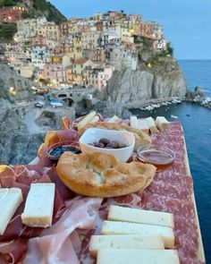 a table topped with lots of food next to the ocean