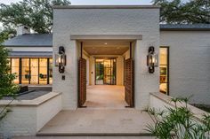 an entry way to a home with brick walls and doors leading into the front yard