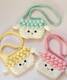 three crocheted purses with sheep faces on the handles, one in pastel colors