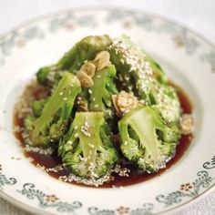 a white plate topped with broccoli covered in sauce