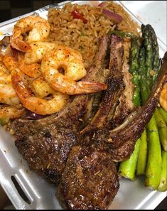 a tray with shrimp, rice and asparagus on it