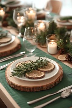 the table is set with plates, silverware and greenery on it's placemats