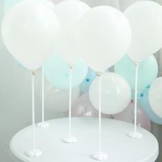 white and blue balloons are on top of a table