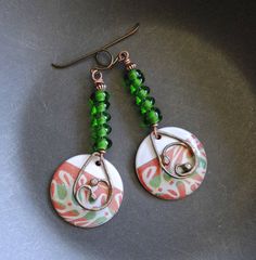 A different twist to your usual holiday earrings featuring green and reddish coral enamel charms. The abstract pattern on the enamels reminds me of a tree branch. I have paired them with spiraling green lampwork beads and copper beads. I have accented them with teardrop shaped copper components. These unique earrings measure 2 1/2 inches in total length and hang on niobium earring hooks. All pieces come boxed ready for gift giving or keeping for yourself. Return to shop: bstrung.etsy.com More li Bohemian Green Jewelry For Holiday, Green Wire Wrapped Beaded Earrings For Gift, Green Wire Wrapped Beaded Earrings As Gift, Green Earrings With Colorful Beads For Gifts, Festive Green Nickel-free Earrings, Green Spiral Earrings As Gift, Handmade Green Beaded Earrings For Holiday, Festive Green Earrings With Colorful Beads, Holiday Green Handmade Beaded Earrings