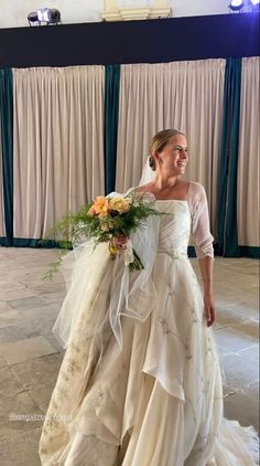 a woman in a wedding dress holding a bouquet