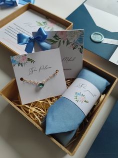 a box with two ties and some cards in it on a table next to other items