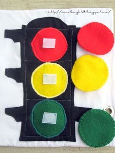 a close up of a traffic light made out of felt on a piece of cloth