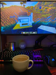 a cup of coffee sitting in front of a computer monitor