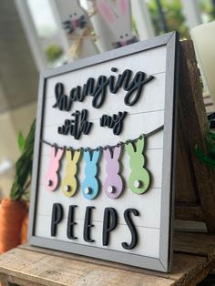 a sign that says hanging with my pees on it next to some carrots