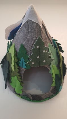 a paper hat with trees and mountains on it